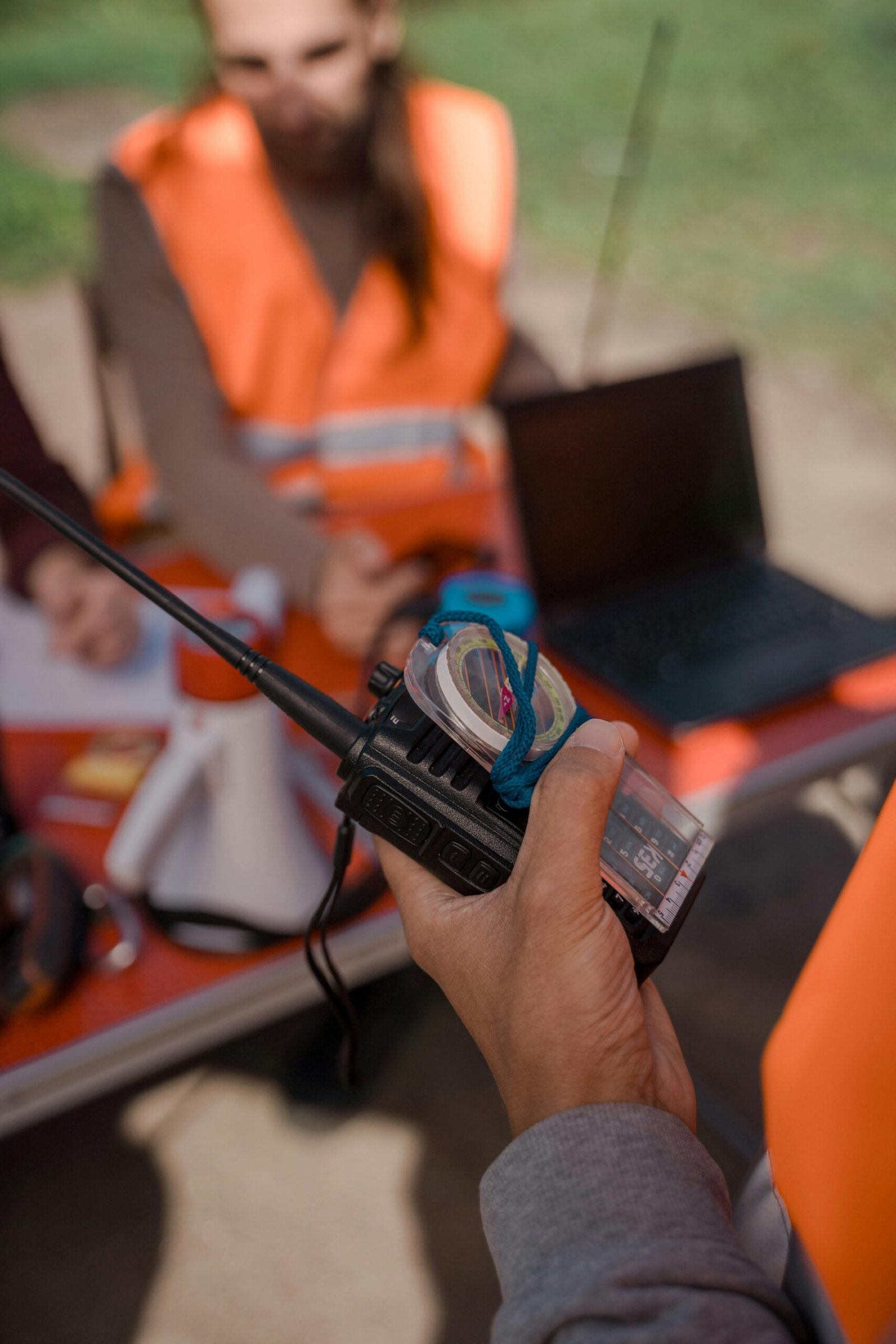 A volunteer using a walkie talkie during an outdoor search operation, enhancing coordination and communication.