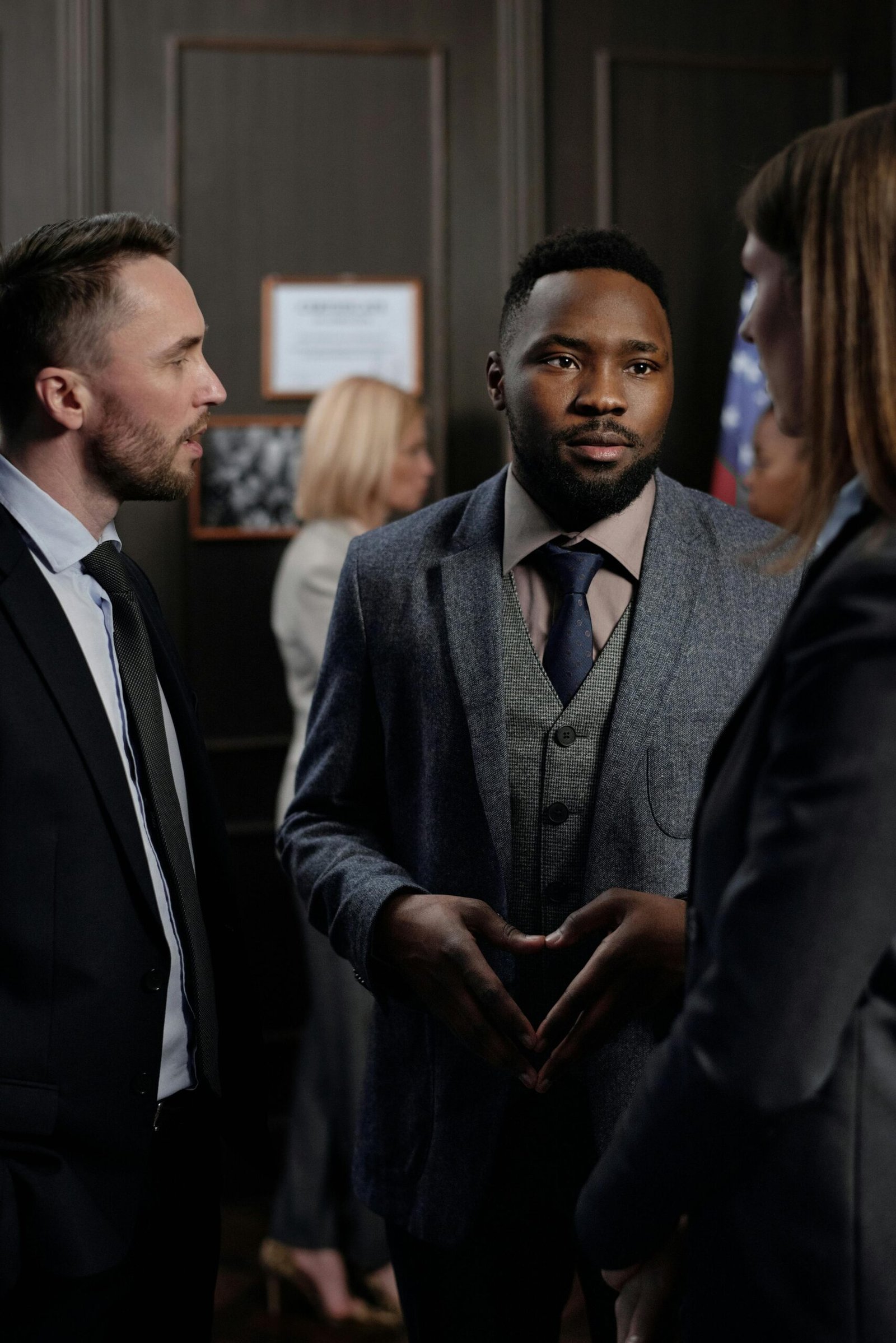 A group of diverse business professionals engaged in a focused discussion indoors.