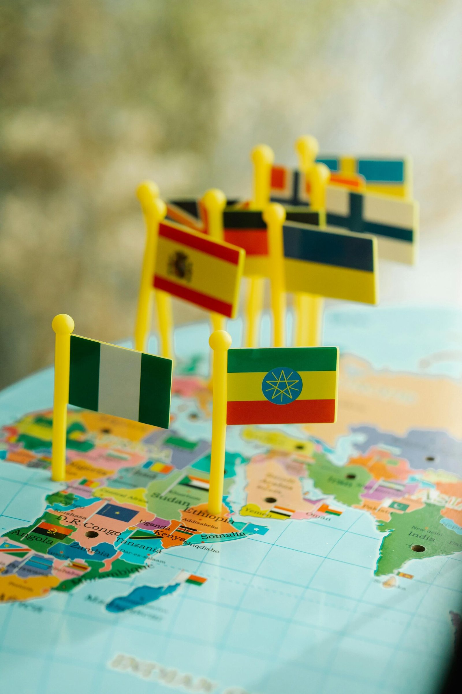 Close-up of small flags marking countries on a colorful world map.